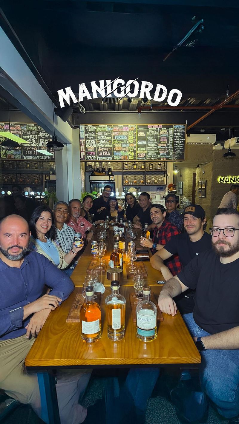 Mesa larga llena de invitados en una cata de ron
